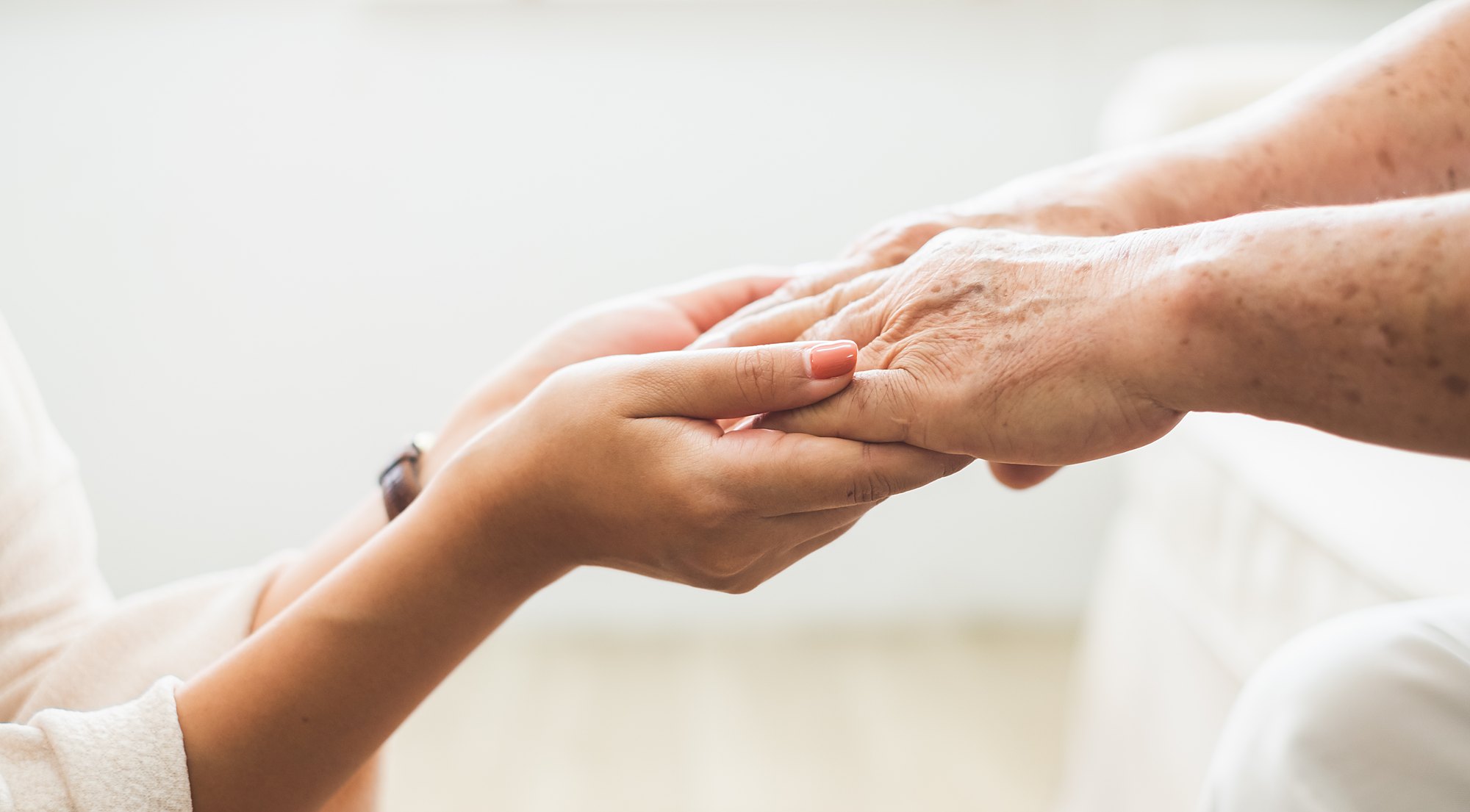 A caregiver holding a resident’s hand
